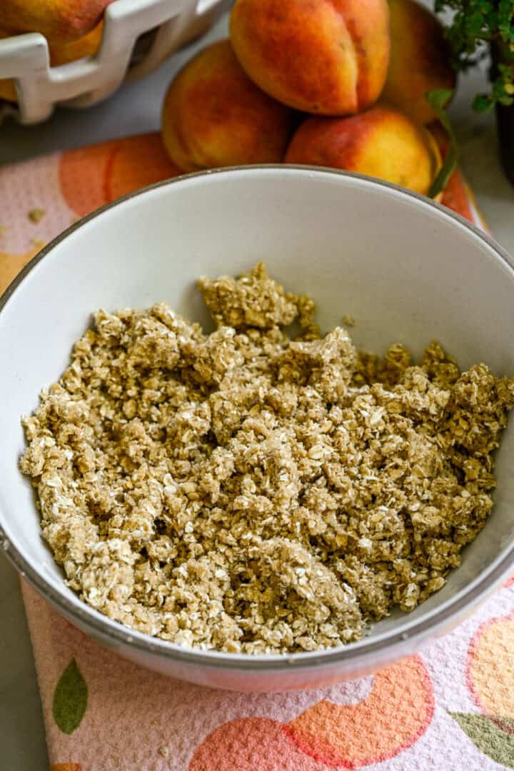Ovanifrån av peach crisp ingredienser i en vit skål.
