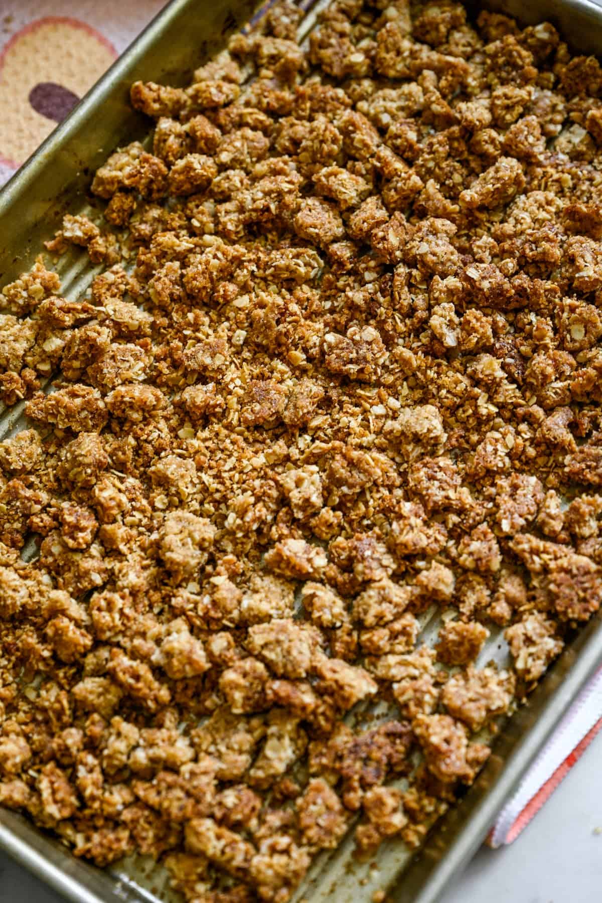 Ovanifrån av peach crisp bruten isär på en plåt.