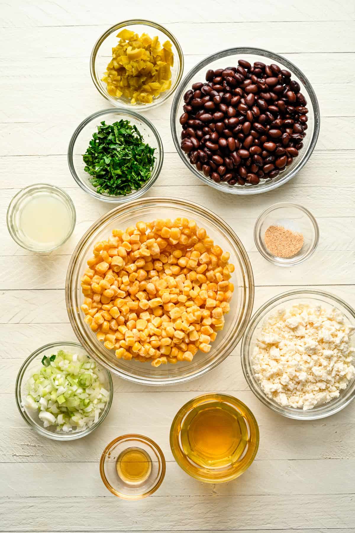 ovanifrån av ingredienser för svarta bönor feta majs dopp i separata skålar. 
