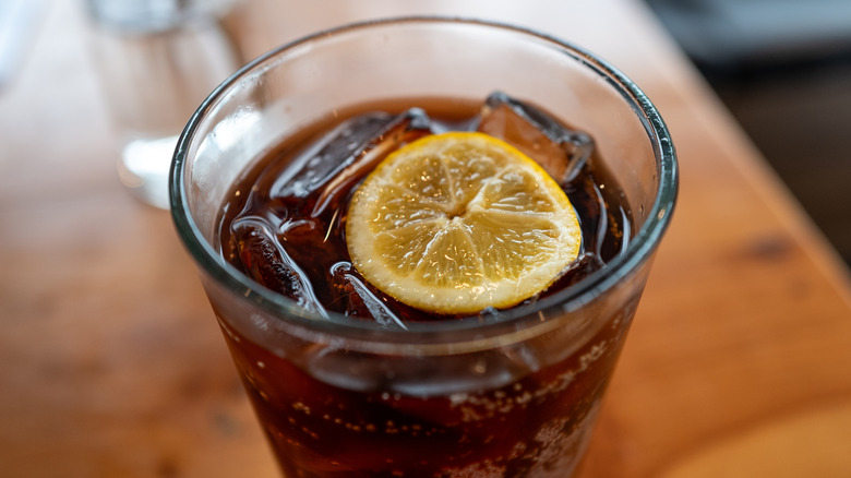 Närbild av en Diet Coca Cola (Diet Coke) läsk med en citronklyfta flytande i den på en restaurang