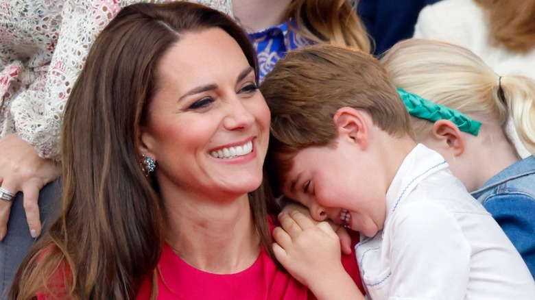 Prins Louis skrattar på mamma Kate Middletons axel