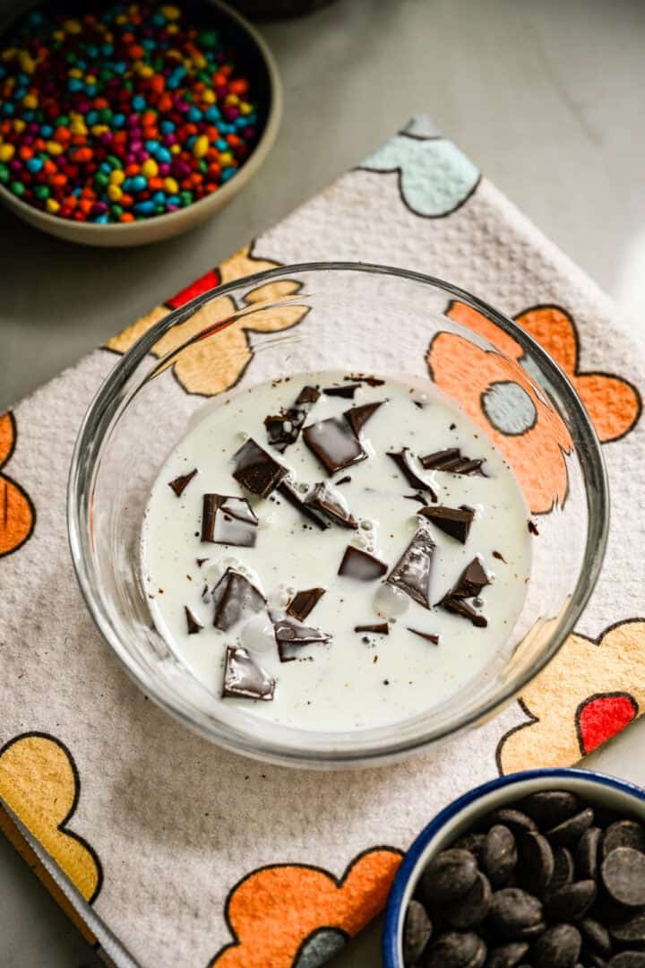 Choklad och tung grädde i en skål innan de vispas till en ganache.