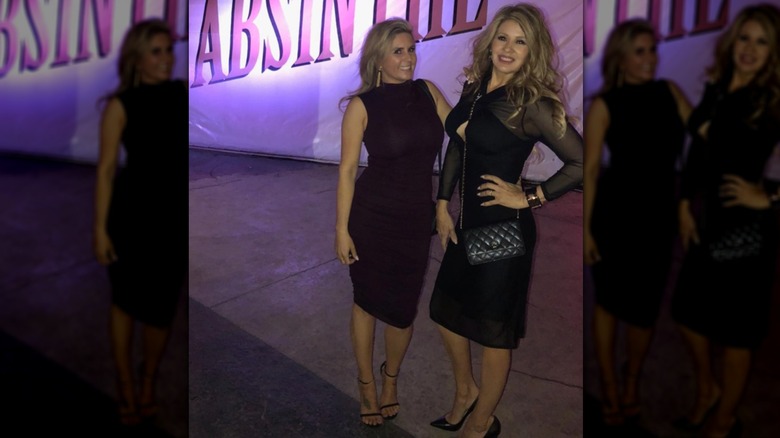 Brandi Passante (L) poserar i en vinröd klänning bredvid en kvinnlig vän (R)
