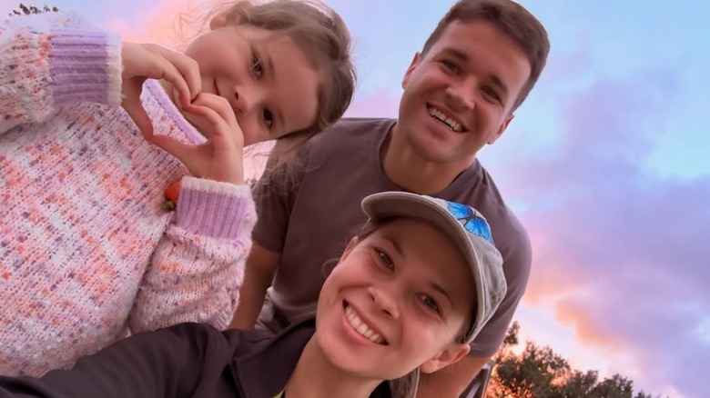 Bindi Irwin, Chandler Powell och dottern Grace Warrior Irwin Powell ler för en familjeselfie
