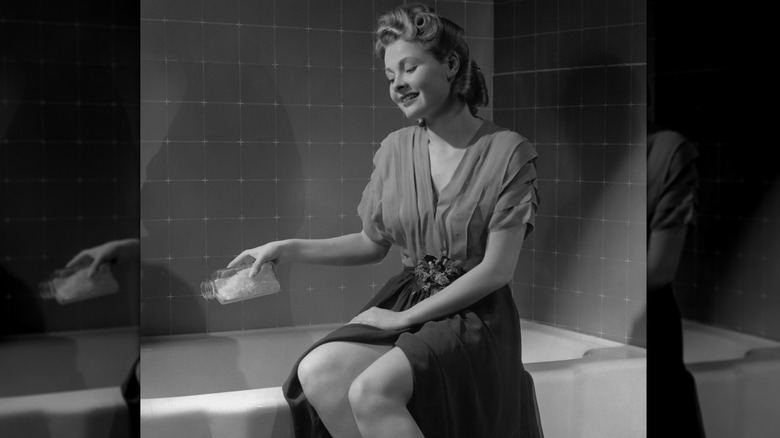 kvinna som gör sig redo att ta ett bad i en bild från 1950-talet