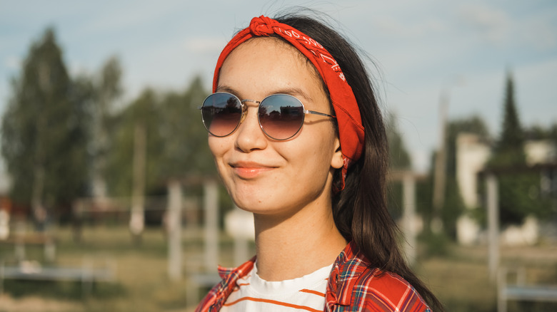 En kvinna som tillbehör med solglasögon och en bandana