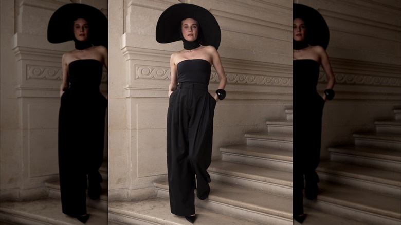 Diane Kruger klädd i en axelbandslös, svart jumpsuit med en svart choker och bredbrättad svart hatt.