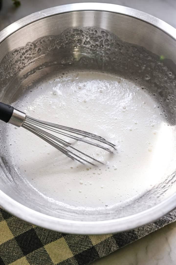 äggvita, socker och grädde av tartar vispad till en skummig blandning över en dubbelkokare.