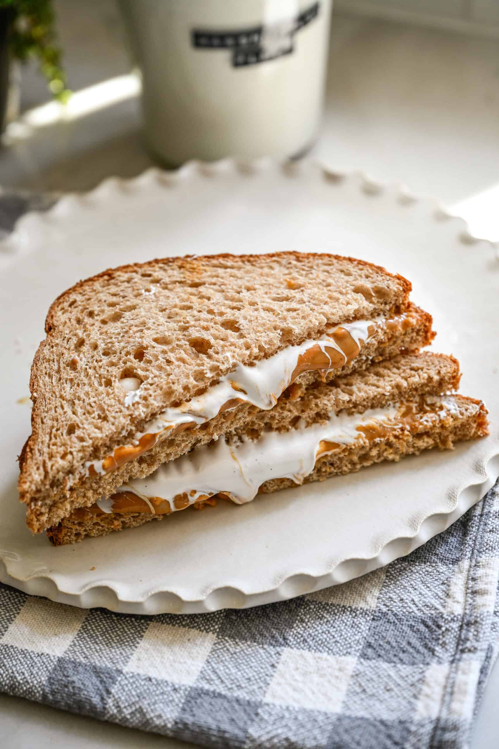 Fluffernutter smörgås med jordnötssmör och marshmallow fluff halverad på en tallrik.