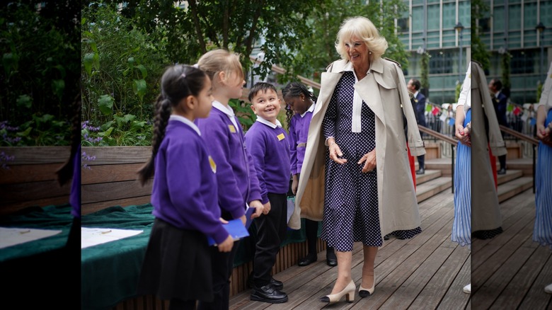 Drottning Camilla går med en skyttegrav draperad över axlarna