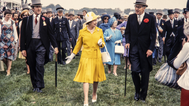 Drottning Elizabeth går i en gul kjolkostym