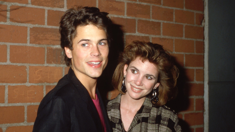 Unga Rob Lowe och Melissa Gilbert framför en tegelvägg