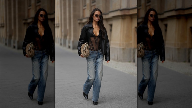 En kvinna bär blåjeans med raka ben, en svart spetsbody och en svart jacka under Berlin Fashion Week 2026.