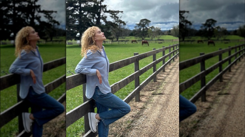 Nicole Kidman poserar utanför, lutad mot ett staket.