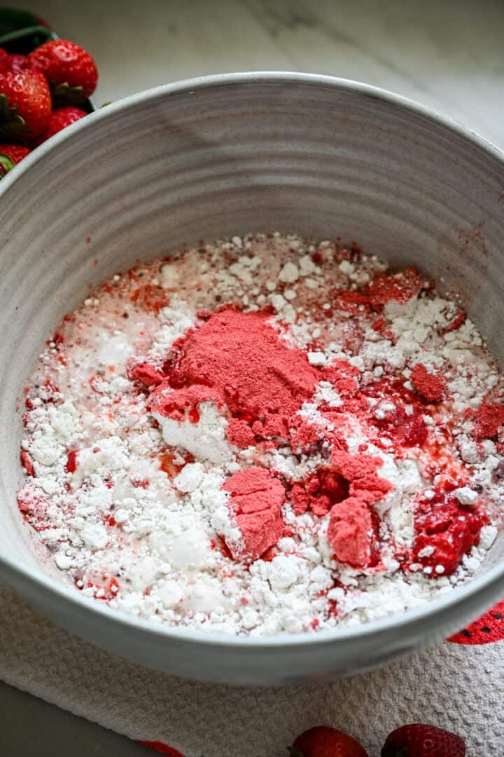 Jordgubbspulver, kakmjöl och vatten i en mixerskål.