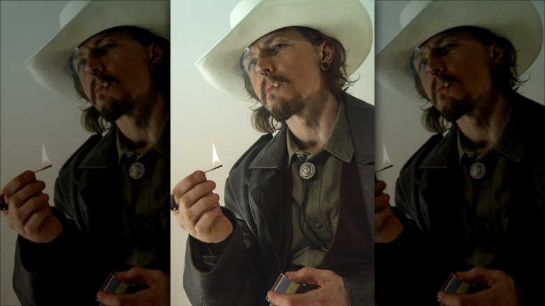 En cowboy som håller en tänd tändsticka