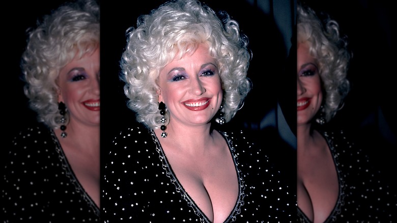 Dolly Parton 1984 klädd i en svart topp prydd med strass.
