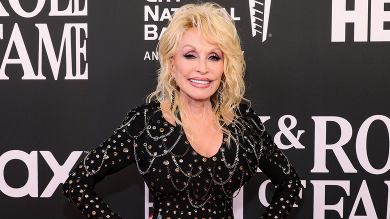 Dolly Parton klädd i en svart klänning med stort hår i 80-talsstil