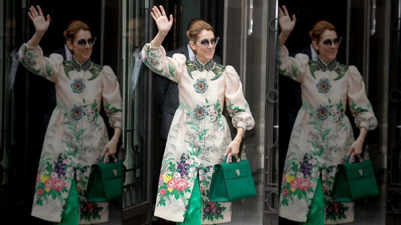 Céline Dion i en blommig kappa vinkar till fansen