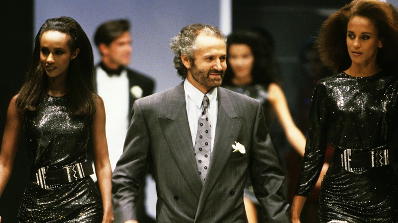 Gianni Versace presenterade sin kollektion 1987 bredvid två modeller