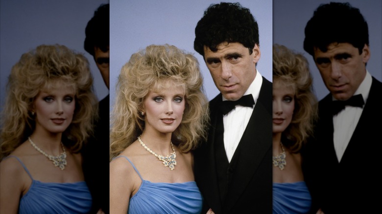 Morgan Fairchild i blå klänning och diamanthalsband och Elliott Gould i smoking på en prisutdelning.