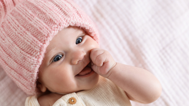 Baby med rosa stickad mössa.