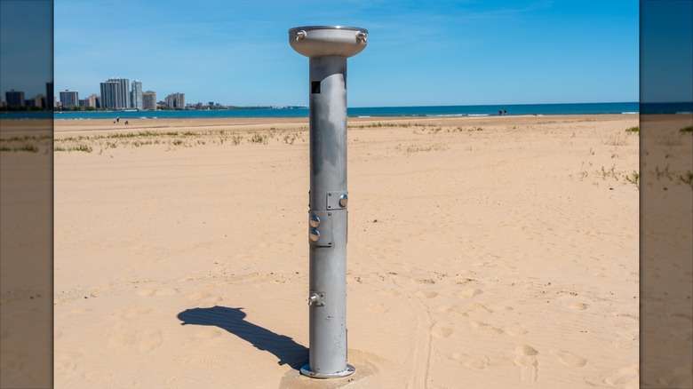 En offentlig utomhusdusch i metall på en sandstrand