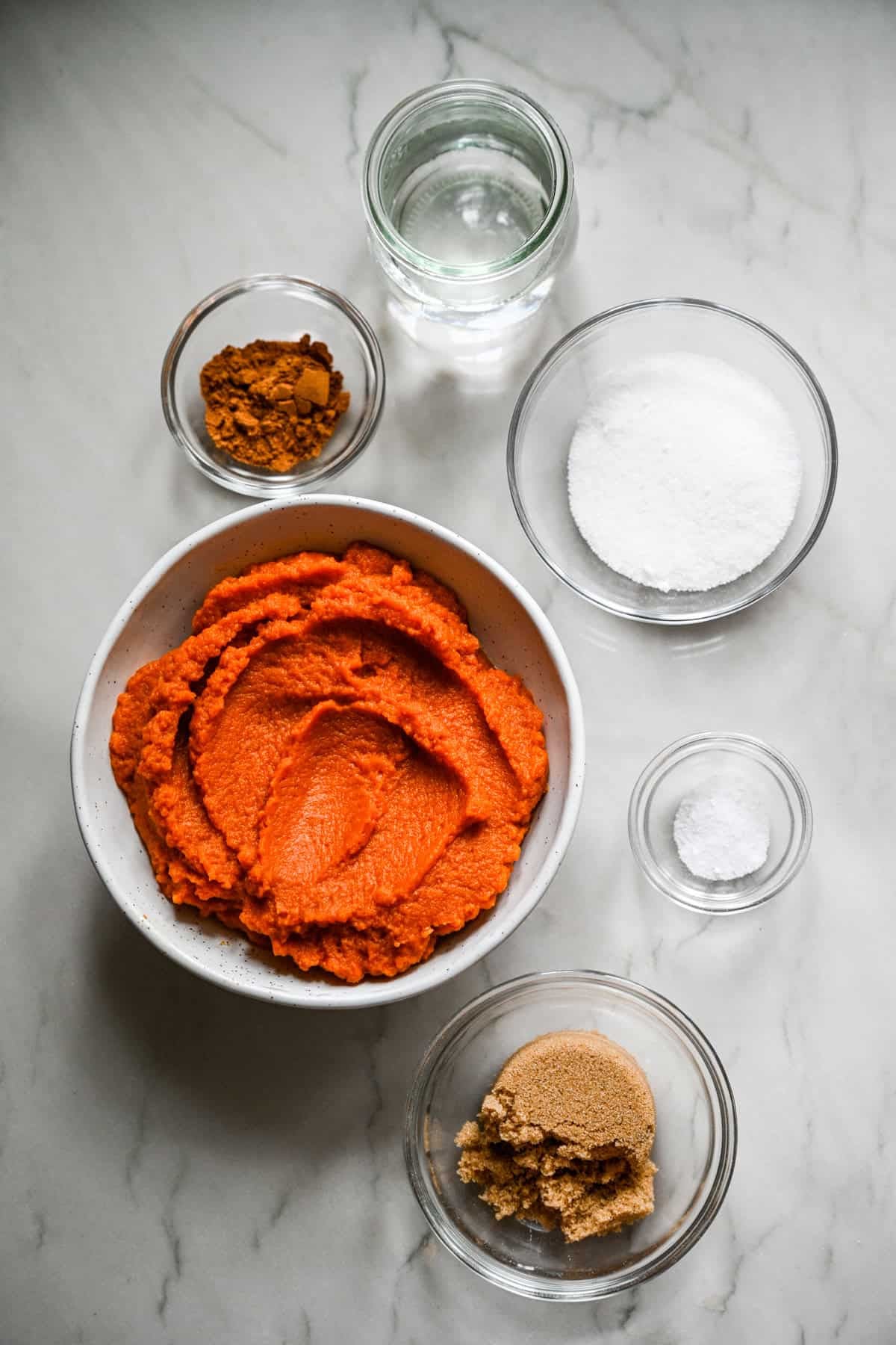 ovanifrån av ingredienser för hemlagat pumpasmör i små prep skålar.