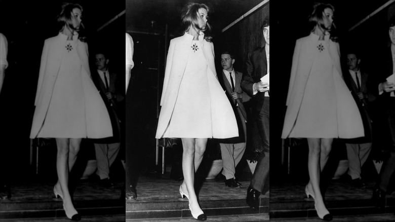 Jean Shrimpton går klädd i en vit miniklänning