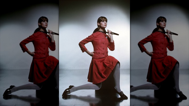 Jean Shrimpton poserar klädd i en röd kostymkjolkoordinat