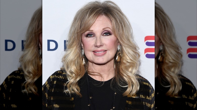 Morgan Fairchild i svart på ett event 2019 med mjukt lockigt hår.