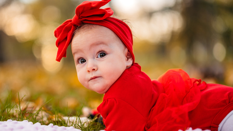 Baby flicka som bär en röd outfit