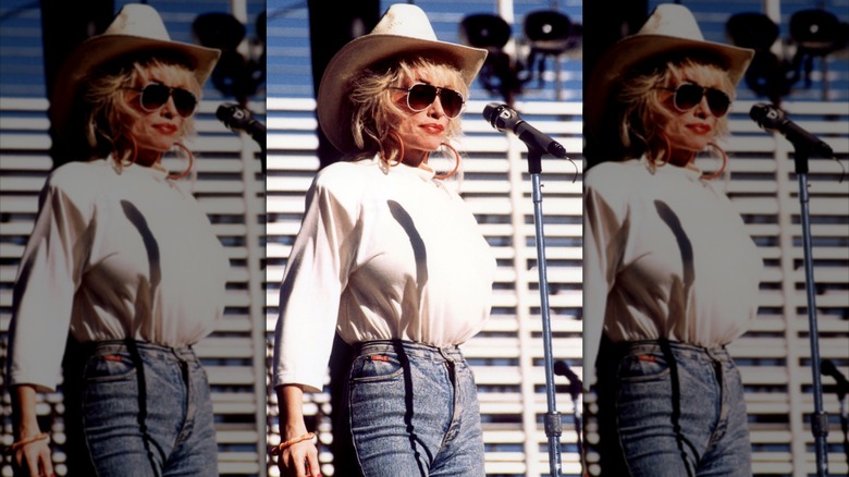 Dolly Parton bar en vit topp, matchande cowgirlhatt och jeans