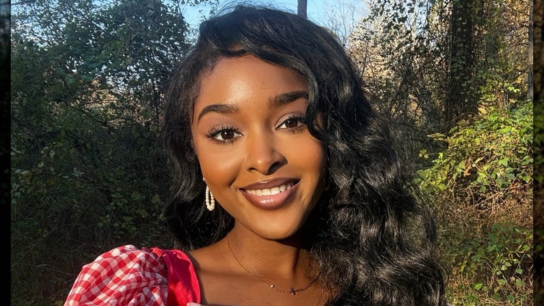 En mörkhyad makeup maven med cottagecore makeup som poserar för ett foto