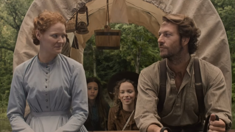 Luke Bracey och Crosby Fitzgerald tittar på varandra längst fram på en täckt vagn med karaktärerna Laura och Mary bakom sig i Netflixs 