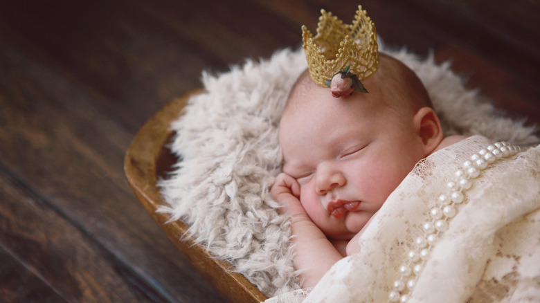 Bebis som sover med ett diadem och en pärlfilt