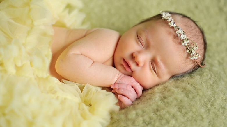 Baby sover med en blomkrona