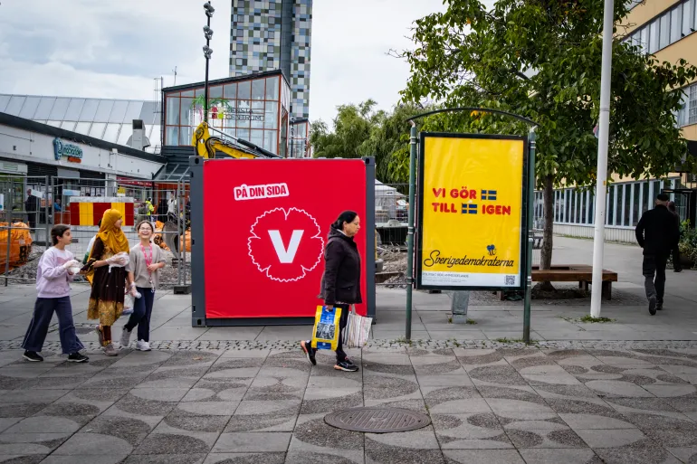 En affisch för Vänsterpartiet (L) och Sverigedemokraterna (R) står sida vid sida i Stockholmsförorten Tensta