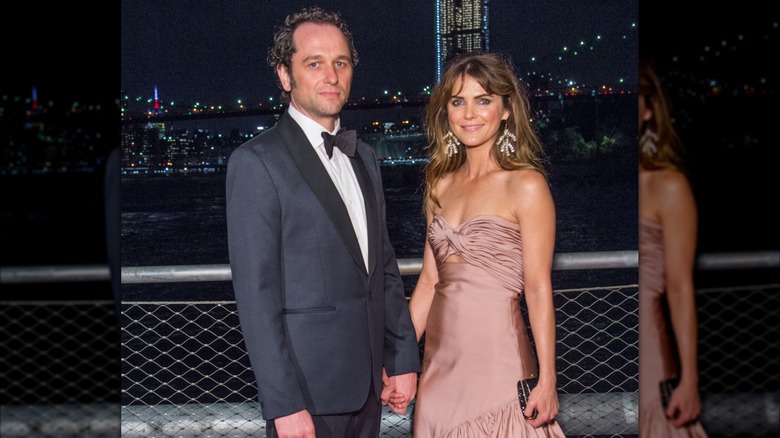 Matthew Rhys och Keri Russell håller varandra i handen när de poserar på ett event i Brooklyn, New York.