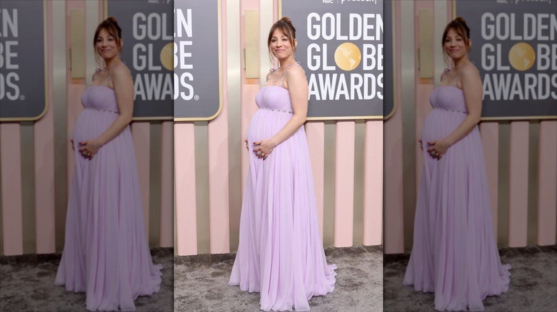 Kaley Cuoco håller i sin babybula iklädd en lavendelklänning