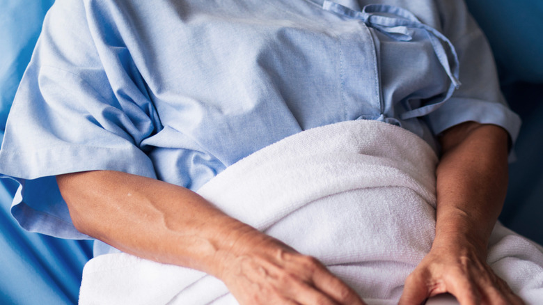 kvinnlig patient i en säng i ett sjukhusrum