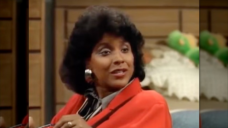 Phylicia Rashad bär örhängen i silver och en orange kavaj