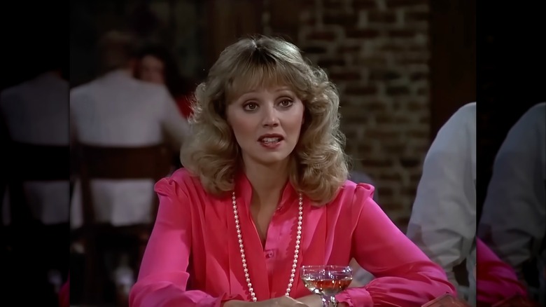 Shelley Long klädd i en rosa blus och ett långt pärlhalsband