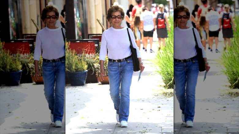 Judy Sheindlin klädd i utsvängda jeans och vit långärmad med svart bälte