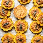 Närbild ovanifrån av fyllda delicata squashringar runt en enda parmesan crisp.