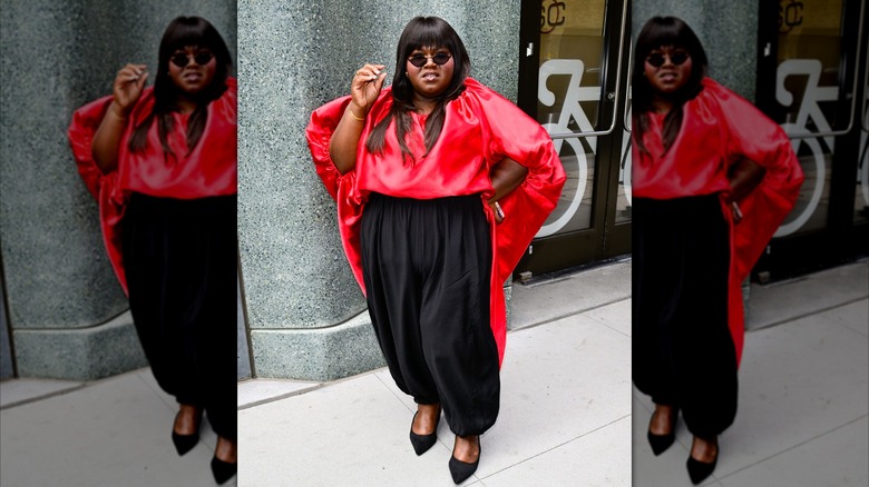 Gabourey Sidibe klädd i en röd skjorta och svarta byxor