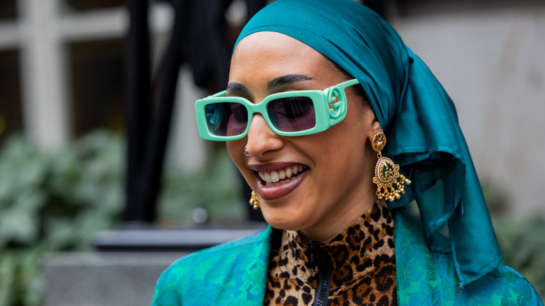 En kvinna som bär skrymmande örhängen med ljuskrona.