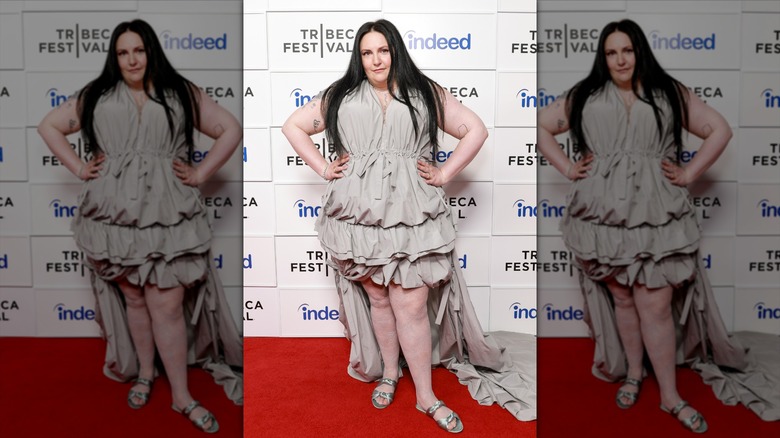 Lena Dunham poserar under ett kändisevenemang iförd en champagnefärgad klänning
