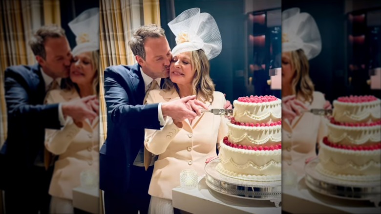 Russell Thomas kysser Kim Cattrall som bär en vit nätfascinator och en vit jacka