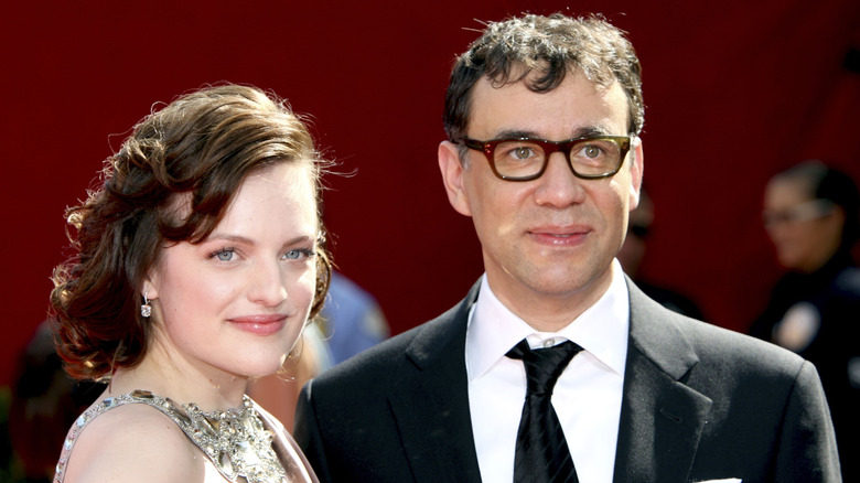 Elisabeth Moss och Fred Armisen tittar på medan de fotograferas tillsammans på ett röda mattan-evenemang